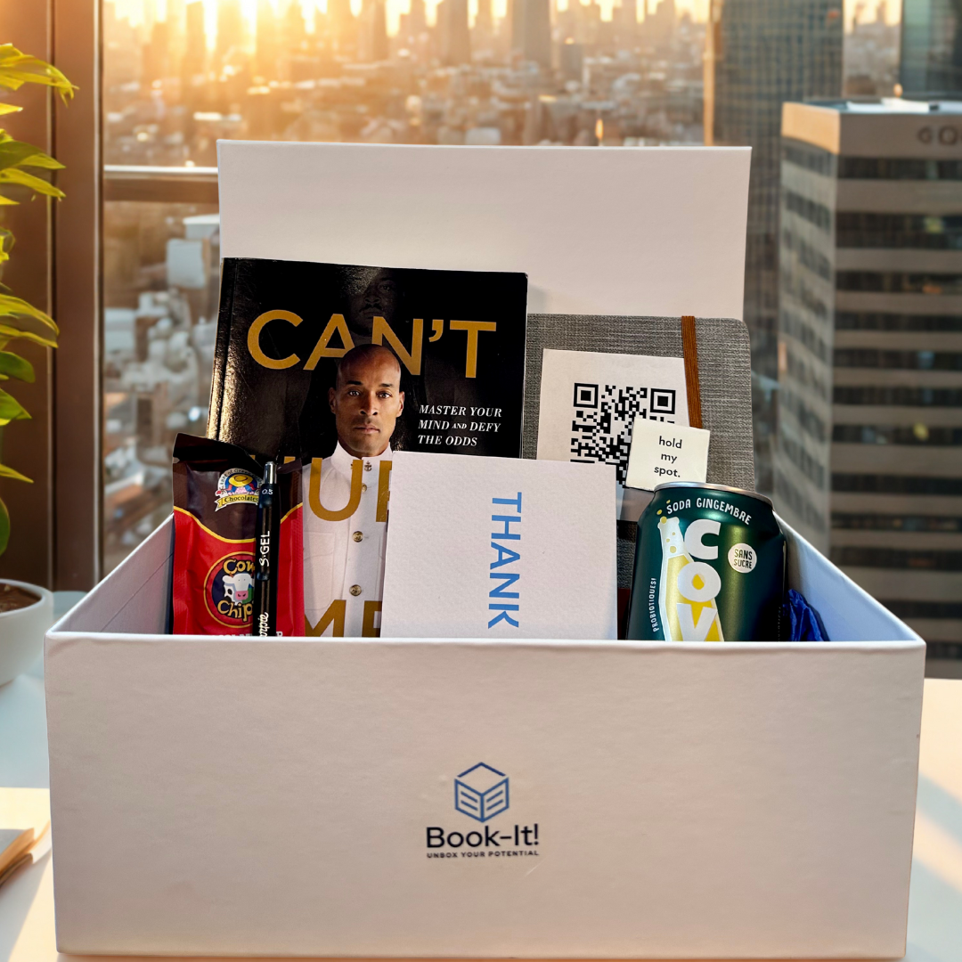 Box with books and snacks on a table with a cityscape background